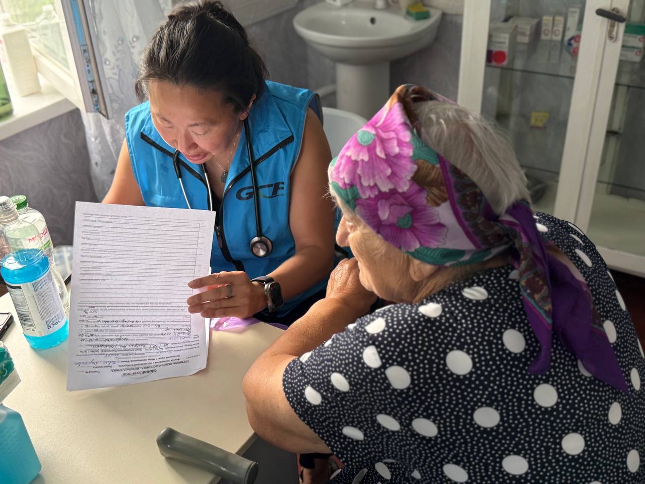 A GCF clinician reviews information with an older patient during a consultation.